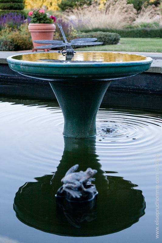 Metal fountain and pool in formal garden