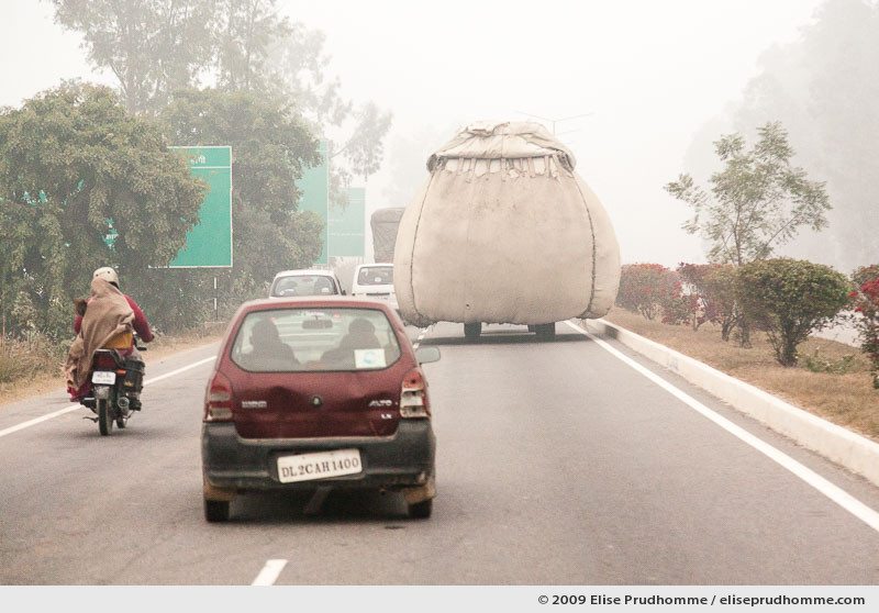 Cars, scooters and overloaded trucks on the Yamuna Expressway connecting Delhi to Agra, India, 2010 by Elise Prudhomme.