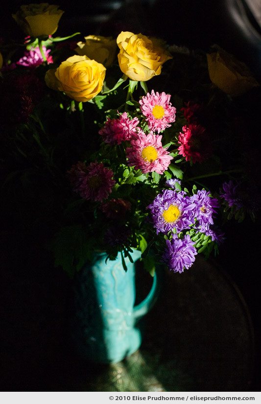 Multi-colored flowers and yellow roses in a turquoise vase in chiaroscuro lighting, Normandy, France, 2010 by Elise Prudhomme.