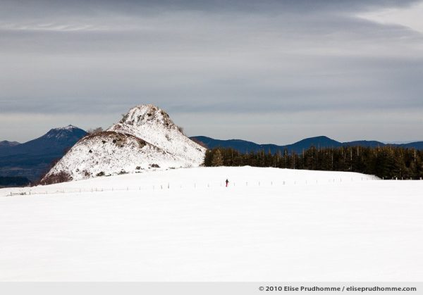 One cross-country skier and the Puy-de-Dôme in the distance, Banne d'Ordanche, Auvergne, France, 2010 by Elise Prudhomme.