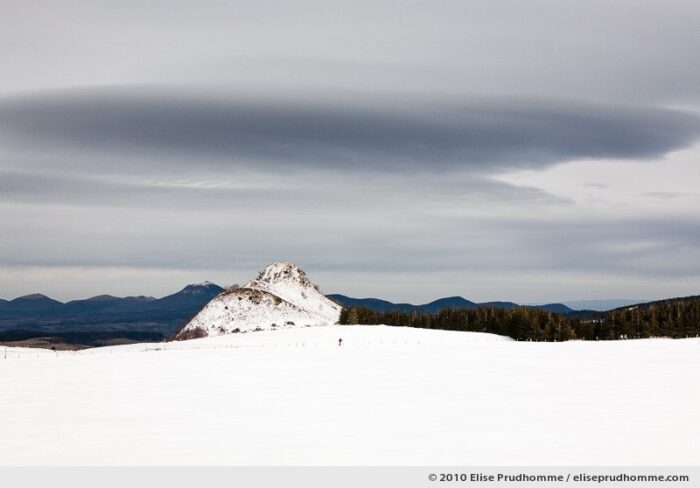 One person cross-country skiing with the Puy-de-Dôme in the distance, Auvergne, France, 2010 by Elise Prudhomme.