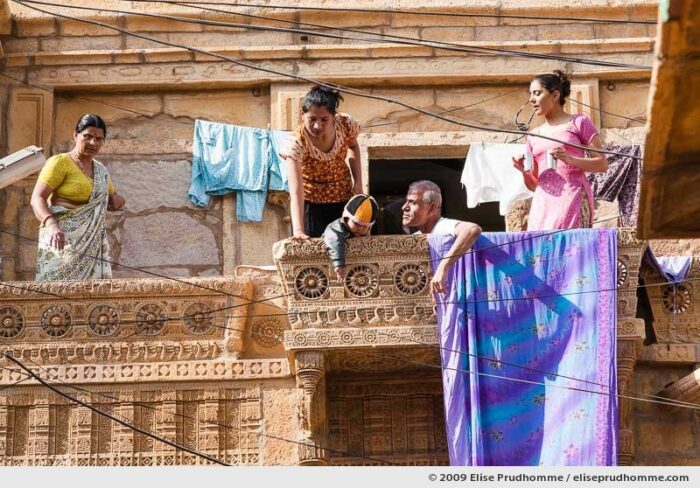 A Rajasthani family takes tea on the balcony of their carved sandstone home in the golden city of Jaisalmer, Rajasthan, Western India, 2009 by Elise Prudhomme.