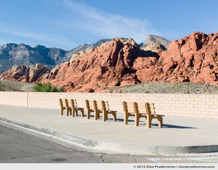 Color photograph of ochre colored visitor's benches at the scenic viewpoint overlooking Red Rock Canyon National Conservation Area, Las Vegas, Nevada, USA.  Bancs publics sans personne et vue panoramique à Red Rock Canyon, Las Vegas, Nevada, USA.