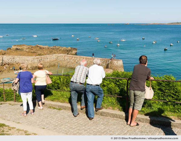 Tourist overlooking picturesque Port Racine, Saint-Germain-des-Vaux, Lower Normandy, France.  Touristes admirent le pittoresque Port Racine, Saint-Germain-des-Vaux, Basse-Normandie, France.