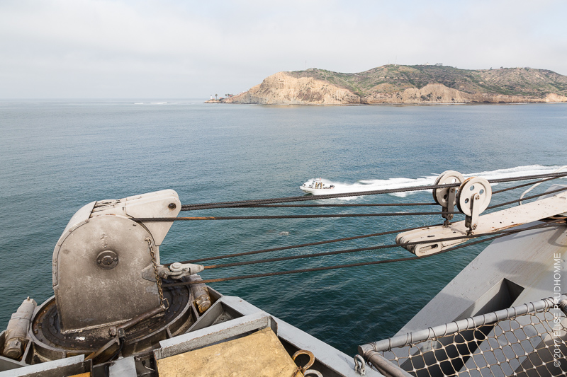 Looking beyond the USS Theodore Roosevelt to the California coast and accompanying armed speed boat.