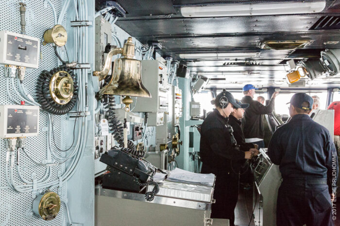 Interior shot of the bridge and a 20-year old sailor at the helm of the USS Theodore Roosevelt.