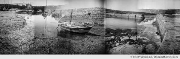 Black and white photograph of boats moored at low tide on the jetty of Port Lévi, Fermanville, France. Series entitled Lieux-dits by Elise Prudhomme.