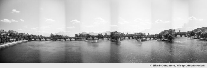 Black and white panoramic photograph of Ile-de-la-Cite, the Seine River and Pont Neuf, Paris, 1st arrdt, France. Analog photography series entitled Lieux-dits by Elise Prudhomme.