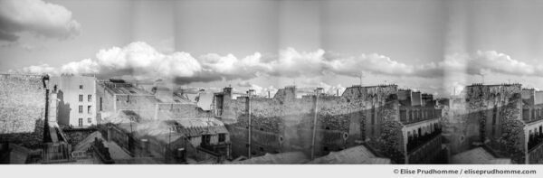 Black and white panoramic photograph of Parisian rooftops and sky, Paris, France. Analog photography series entitled Lieux-dits by Elise Prudhomme.
