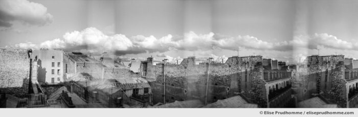 Black and white panoramic photograph of Parisian rooftops and sky, Paris, France. Analog photography series entitled Lieux-dits by Elise Prudhomme.