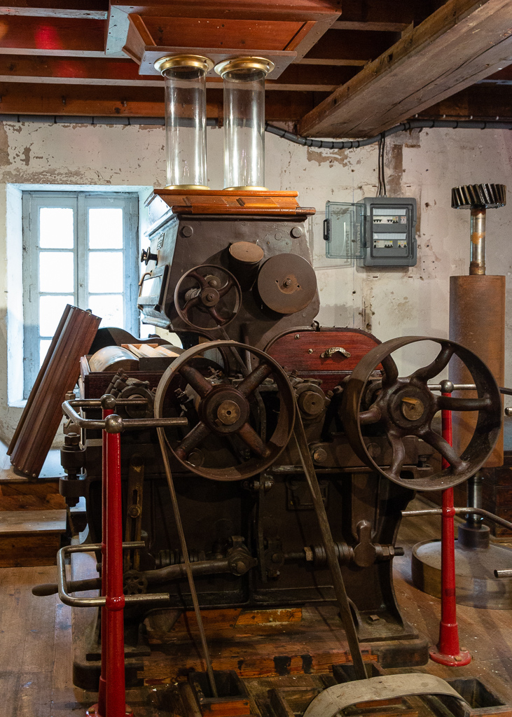 This roller mill, built in the workshops H. & G. Rose brothers of Poissy, is part of the crushing equipment of Saint-Gabriel Flour Mill. Its hull of metal and wood envelops cast iron cylinders that grind wheat grains falling from glass supply globes. Several successive passages between different cylinders are necessary to obtain a white flour.