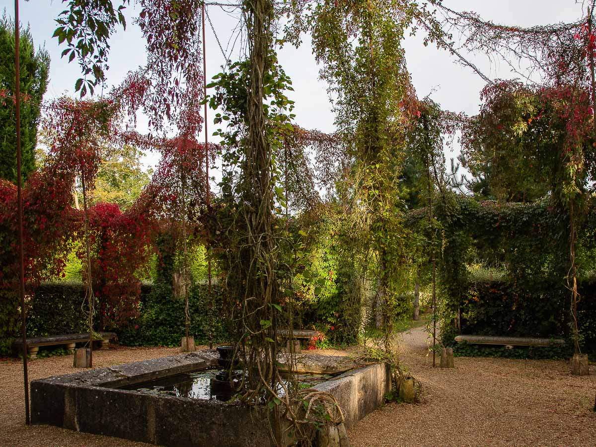 Hanging gazebo made from chains with Virginia creeper in the formal gardens of the Chateau du Champ de Bataille, Normandy, France.